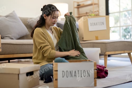 Preview: Volunteer Sorting and Donation Clothes for Charity in a Modern Living Room Setting, Highlighting