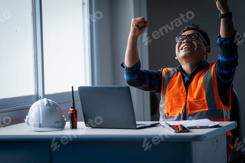 Preview: Happy engineer working on personal computer at construction site,Successful concept.