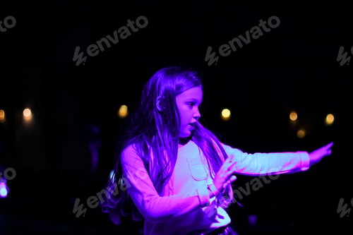 Vorschau: Schönes emotionales junges Mädchen, das im Neonlicht tanzt. Menschliche Emotionen, Konzept des Gesichtsausdrucks.