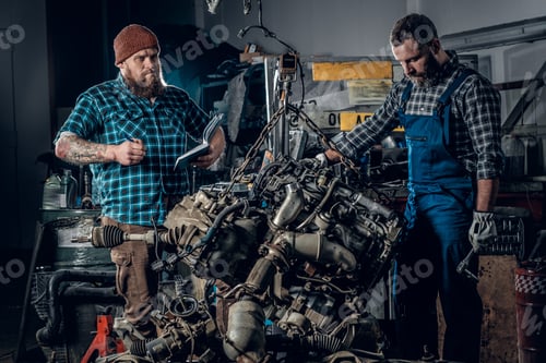 Preview: Two men in a garage.