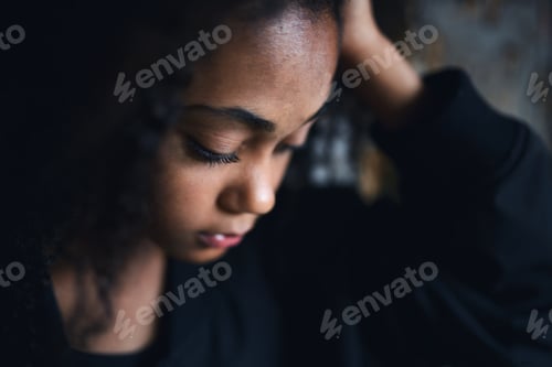 Preview: Close-up portrait of sad mixed-race teenager girl standing, bullying concept.