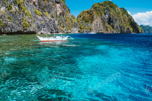 Preview: Banca boat moored und crystal clear ocean water near Matinloc island, highlights of hopping trip