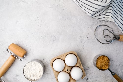 Preview: Baking pastry and cake ingredients with wooden utensil on light stone concrete.