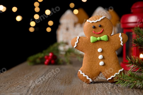 Preview: Gingerbread man on wooden table against blurred lights, closeup. Space for text