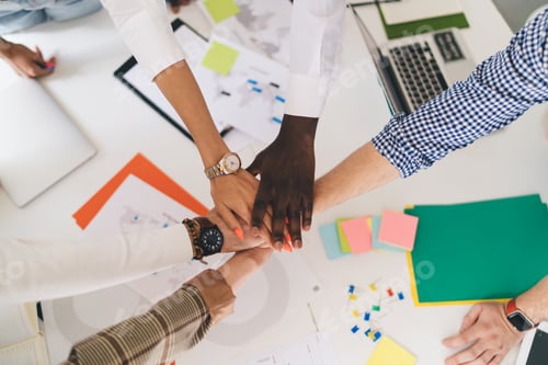 Preview: Crop team mates gathering hands to show unity