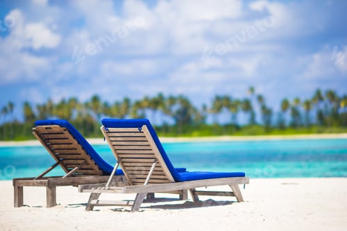 Preview: Lounge chairs with bag and hat on tropical white beach