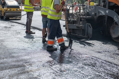 Preview: Workers operating asphalt paver machine during road construction and repairing works