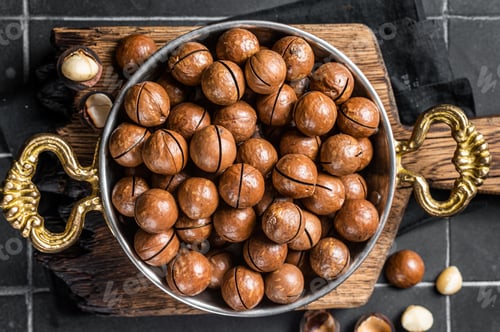 Preview: Macadamia nuts in a shell ready to eat. Black background. Top view