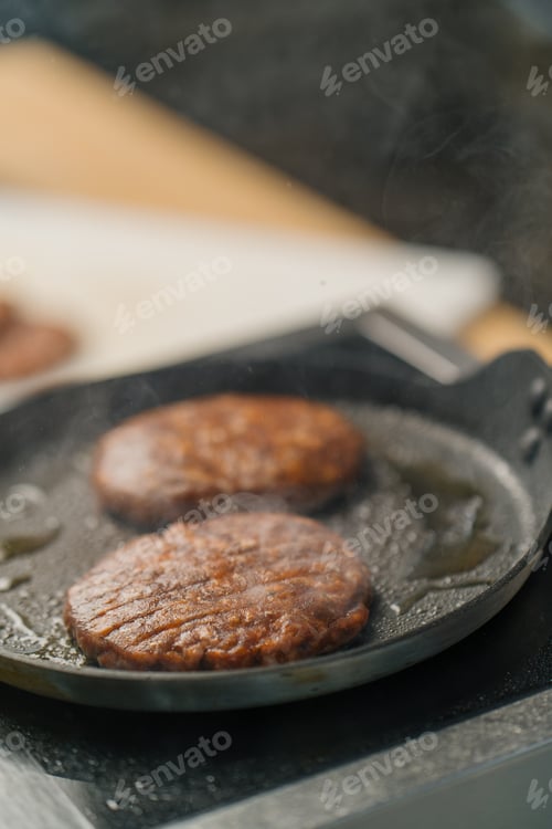 Preview: A professional kitchen chef is frying cutlets for a burger