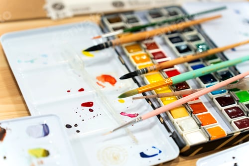 Preview: Palette of Watercolors and Brushes on Wooden Surface