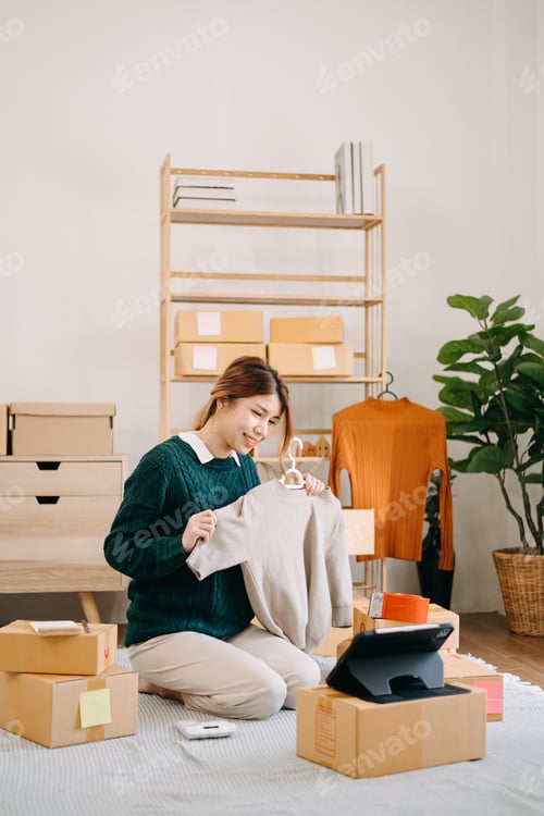 Preview: Portrait of Asian young woman SME working using smartphone or tablet taking receive