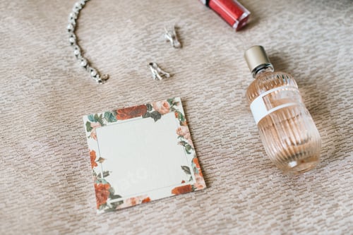 Preview: elegant bottle of perfume on the armchair with a pink necklace