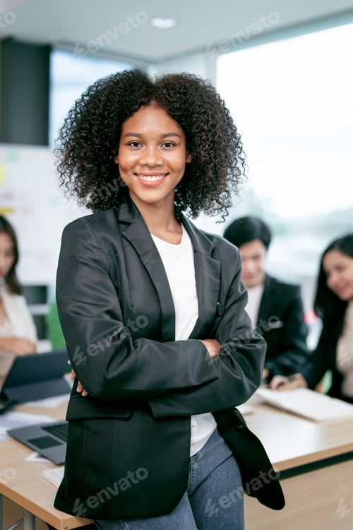 Preview: Portrait of beautiful african woman standing in front of business team at office.