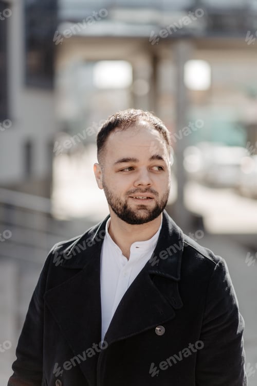 Preview: Portrait of fashionable well dressed man with beard posing outdoors