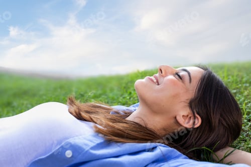 Preview: Relaxed Woman Lying in Green Grass Outdoors