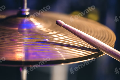 Preview: Hi-hat close-up of plates with drumsticks on a background of colored lanterns.