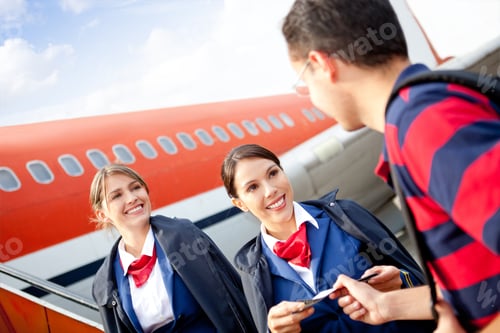 Preview: Friendly Flight Attendants Welcoming Passenger Into The Airplane