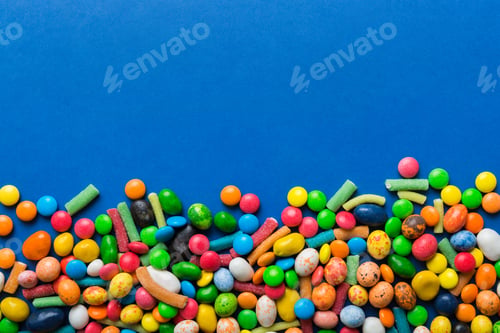 Preview: Mixed collection of colorful candy, on colored background. Flat lay, top view