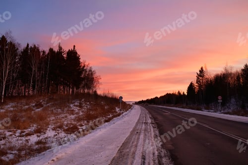 Preview: Bright colorful dawn in winter. Paved road outside the city