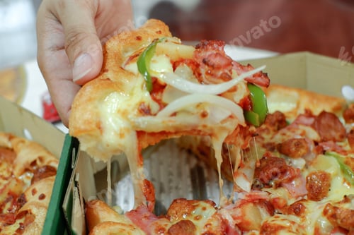 Preview: pizza with ham, by cut to pieces on table. selective focus on the filling close-up.