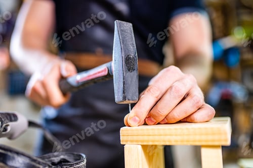 Preview: Portrait of handsome carpenter working with plank in workshop