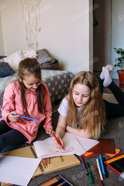 Preview: Two girls friends play at home after school, draw with pencils and felt-tip pens and have fun.