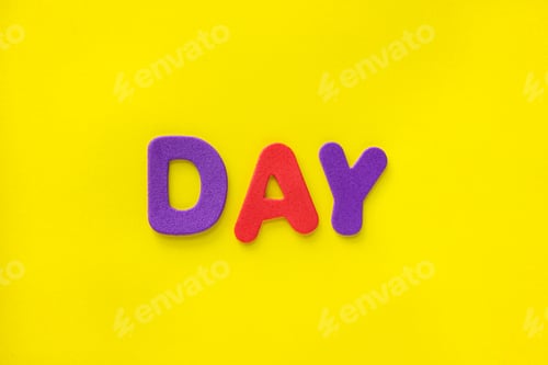 Preview: Colorful Day text letters isolated on yellow background with copy space.