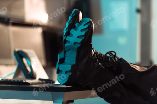 Preview: cropped image of prison guard sitting with legs on table
