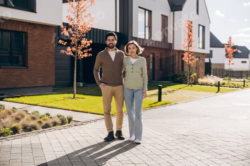 Aperçu: Happy smiling couple hugging standing outside their new modern house