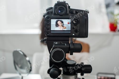 Preview: selective focus of digital camera with happy african american video blogger in braces holding lip