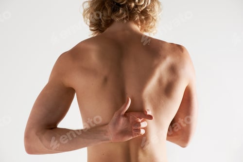 Preview: What you cant see...Rear view of a young shirtless man gesturing behind his back.