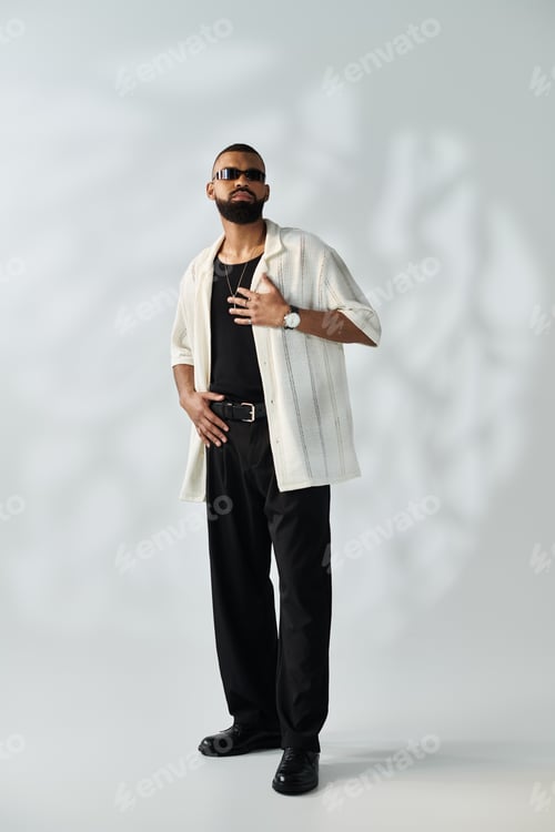 Vista previa: Stylish young man exudes confidence in modern fashion against a minimalist background