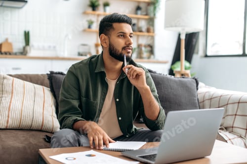 Preview: Pensive clever indian or arabian guy, student or freelancer, using laptop, working or studying