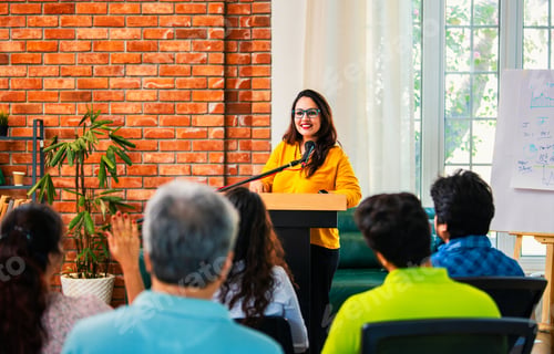 Preview: Indian Asian Confident life coach addressing entrepreneurs at a business event with a microphone