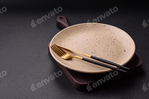 Preview: Cutlery fork, knife and spoon on a dark textured concrete background