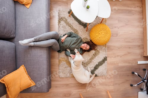 Preview: Woman and dog lying on floor spending time at home together