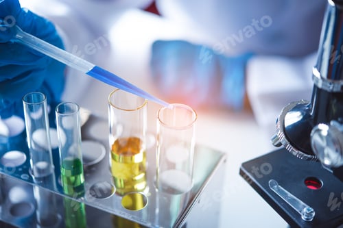 Preview: closeup-pipette dropping a sample into a test tube in an experiment research in laboratory.