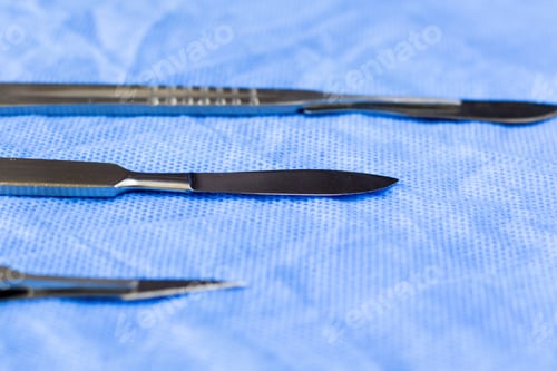 Preview: Selective focus shot of different surgery scalpels on the sterile table