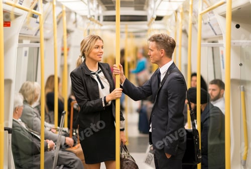 Preview: Businessman and businesswoman talking in tube, London Underground, UK