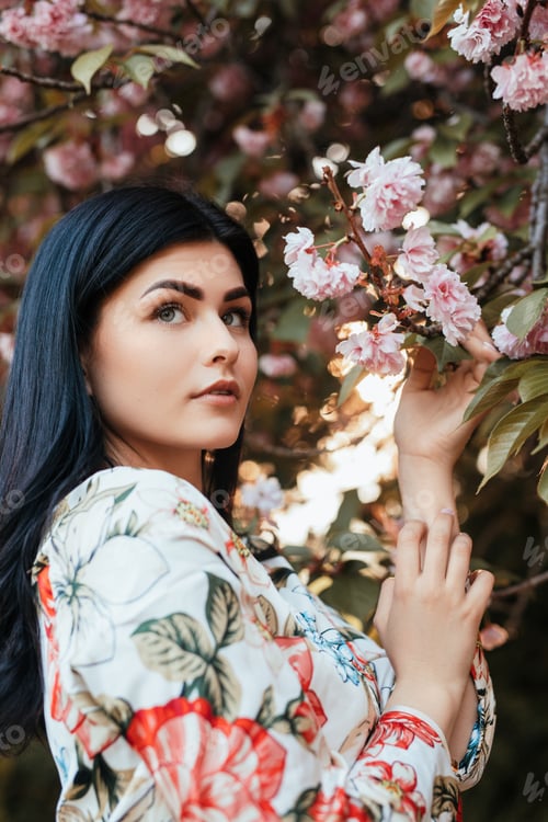 Preview: Elegant woman near blooming tree
