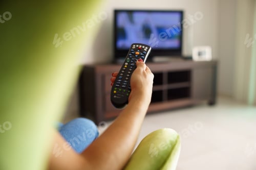 Preview: Woman On Sofa Watching Tv Changing Channel With Remote