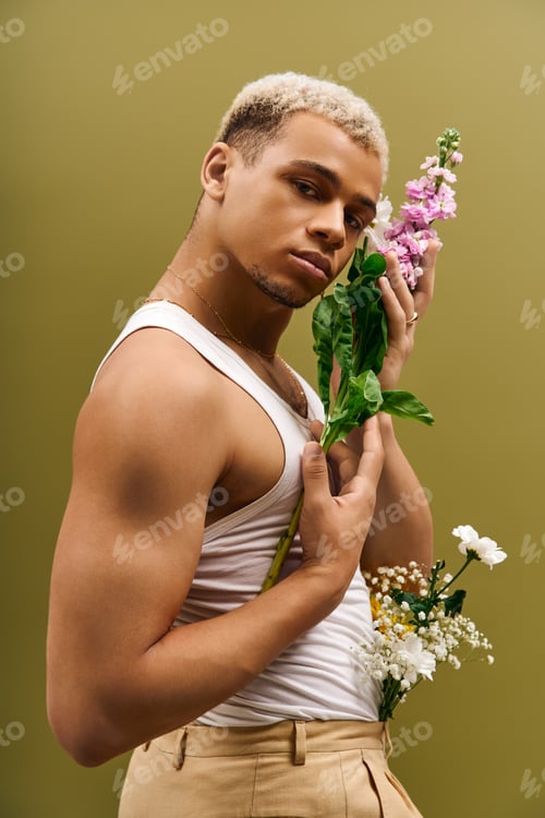 Preview: Young man showcases trendy style in studio with fresh flowers and vibrant energy