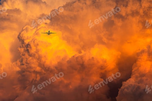 Preview: Plane fly over dramatic orange sky and clouds abstract background. Top view of orange clouds