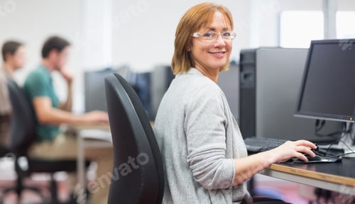 Preview: Portrait Of A Smiling Woman By Other Mature Students Using Computers In The Computer Room