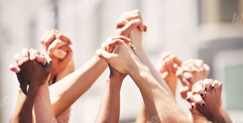 Preview: Together theyre unbeatable. Shot of a group of people with their fists raised at a protest.