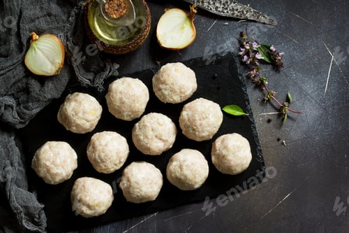 Preview: Homemade turkey meatballs raw on slate blackboard. Flat lay.