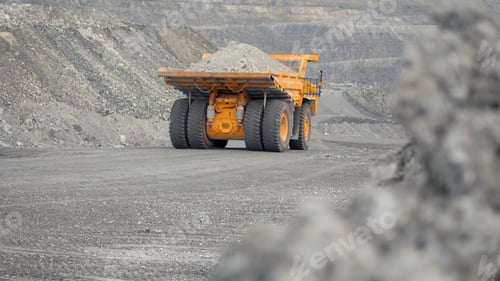 Preview: Close-up of dump truck moving on a quarry road loaded with ore. Back view.