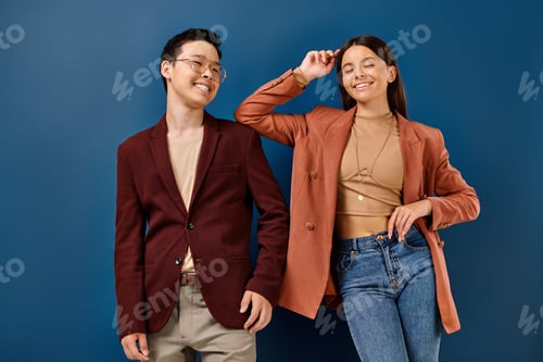Preview: joyous elegant multicultural teens in stylish outfits smiling on blue backdrop, friendship day