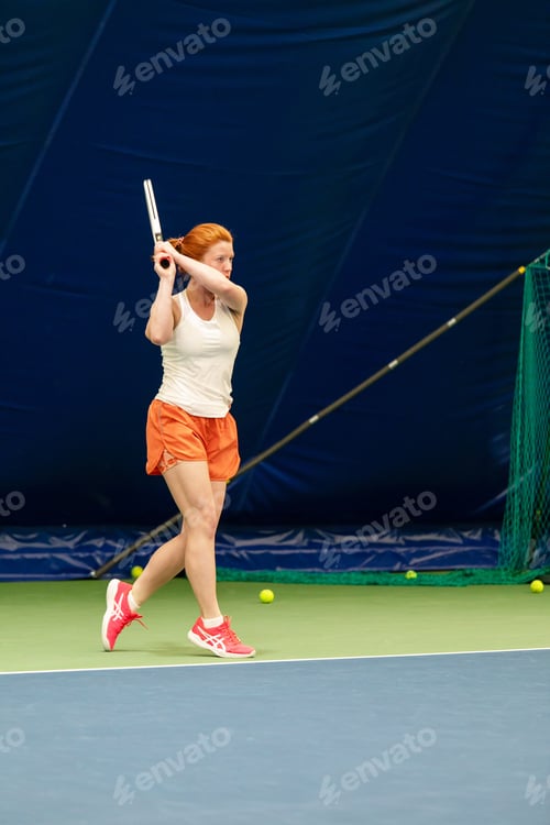 Preview: A woman plays tennis on an indoor court