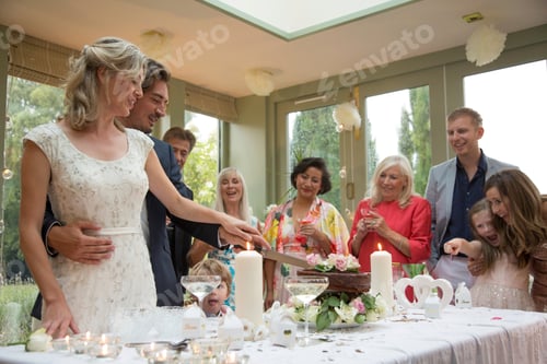 Preview: Newlyweds cutting wedding cake at reception